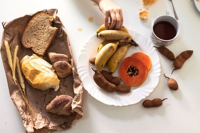 Cropped hand of person having breakfast on table