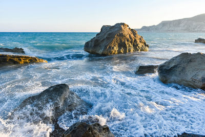 Rocks in sea against sky