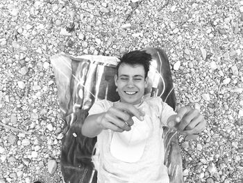 Directly above shot of happy teenage boy relaxing on field