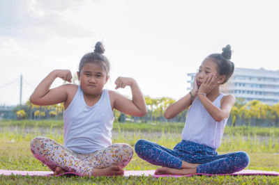 Sisters sitting on yoga mat at park