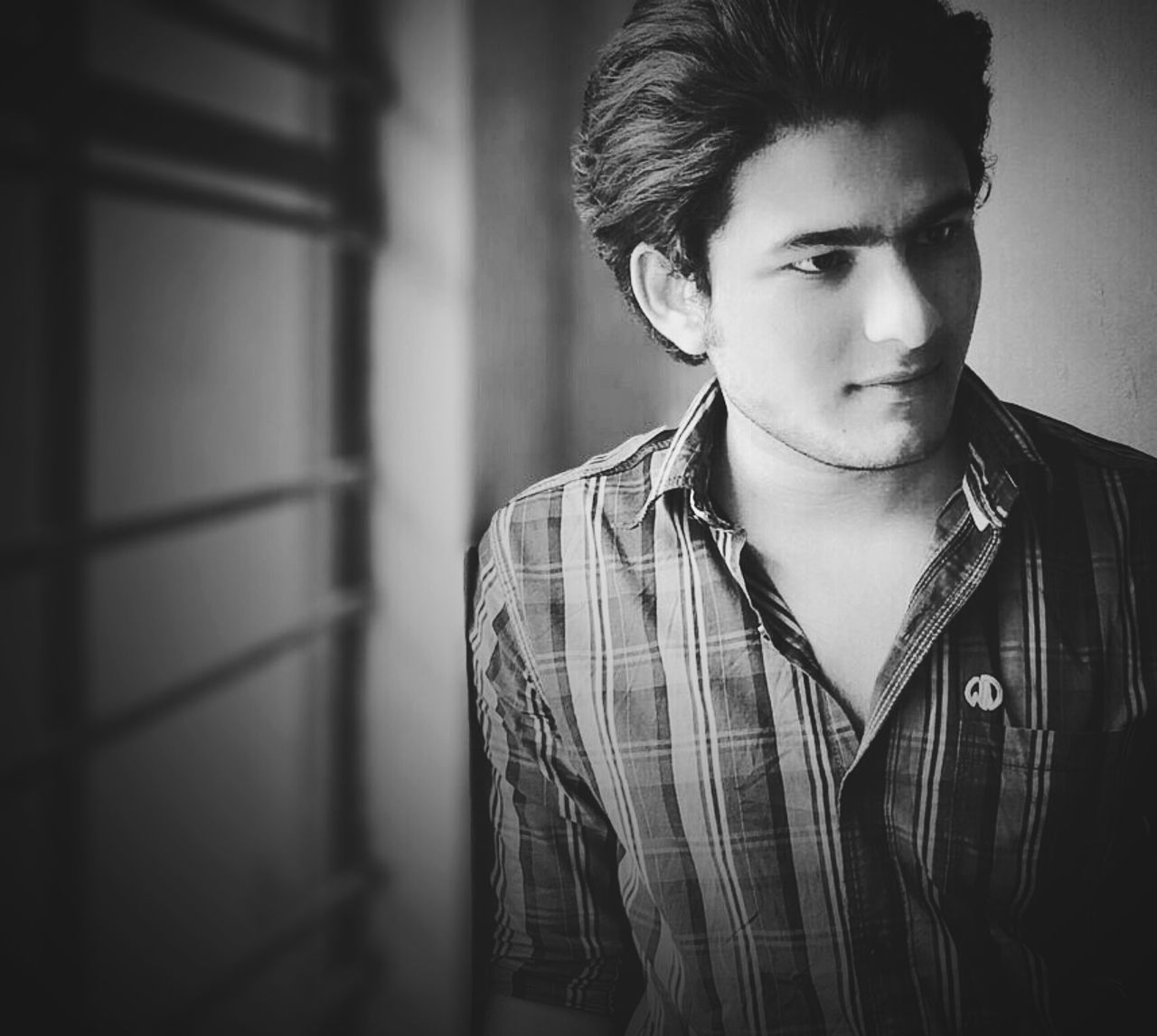 portrait, looking at camera, person, young adult, front view, lifestyles, indoors, headshot, focus on foreground, casual clothing, contemplation, serious, confidence, young men, leisure activity, close-up, smiling