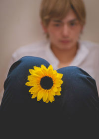 Close-up portrait of woman with yellow flower