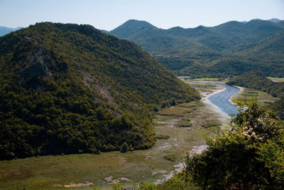 High angle view of river amidst mountains against sky