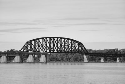 Arch bridge over river against sky