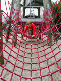 Boy playing on jungle gym at playground