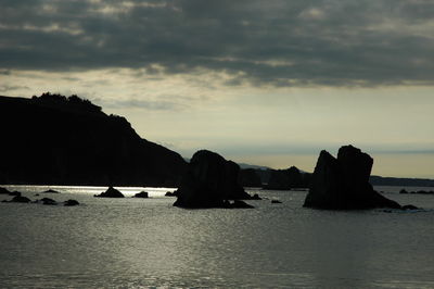 Rocks on sea against sky during sunset