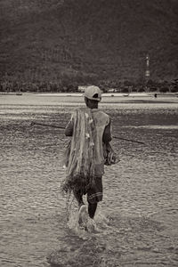 Rear view of man standing in puddle