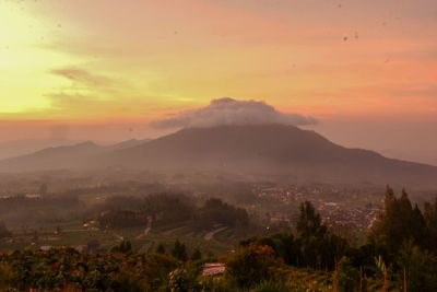 Scenic view of mountains against orange sky