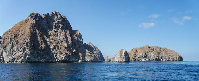 Panoramic view of rock formation in sea against sky