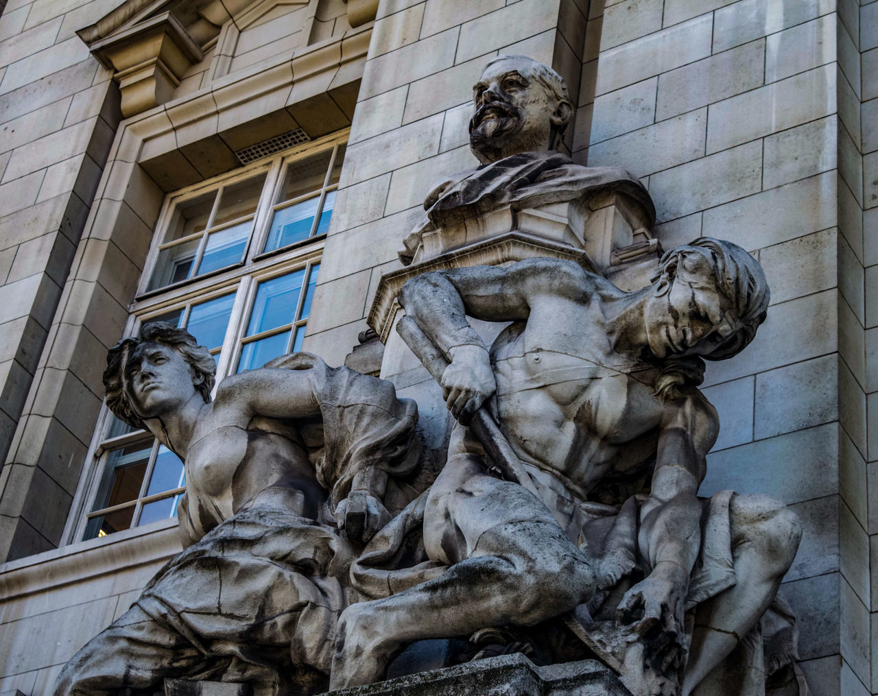 LOW ANGLE VIEW OF STATUE AGAINST BUILDINGS IN CITY