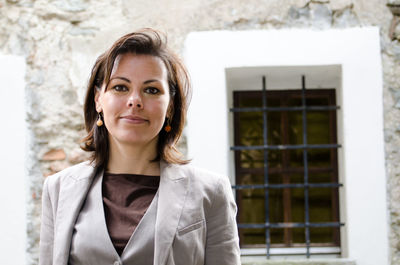 Portrait of mature woman standing against building