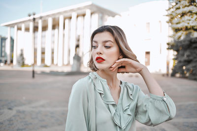 Woman looking away while standing in city