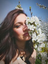Portrait of beautiful woman with white flowers at park