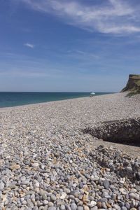 Pebbles on beach against sky