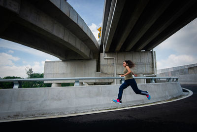 Full length of woman on bridge in city against sky