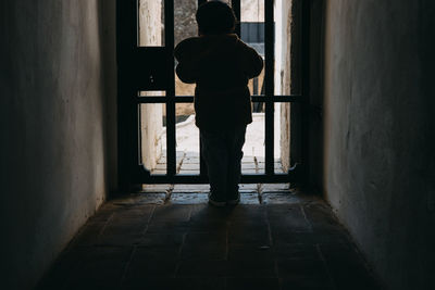 Rear view child against iron door