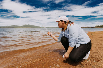 Side view of senior woman on beach against sky