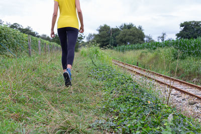 Rear view of woman walking on field