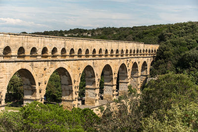 View of historical building pont du gard against cloudy sky