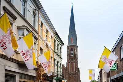 Low angle view of buildings by church in town