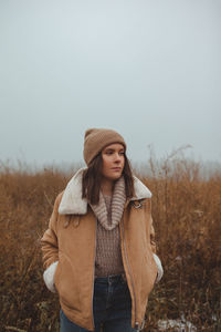 Women standing in a foggy late autumn winter field against sky