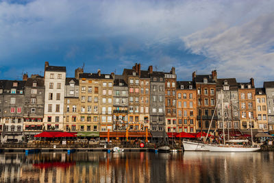 Buildings in city against cloudy sky