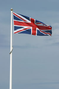 Low angle view of flag flags against sky