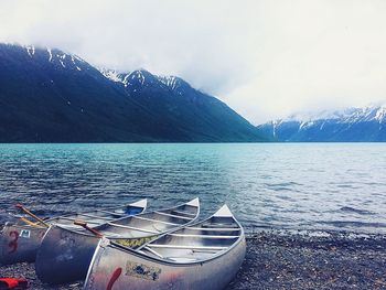 Scenic view of lake by mountains against sky