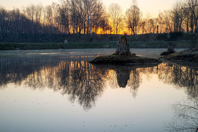 Scenic view of lake against sky at sunset