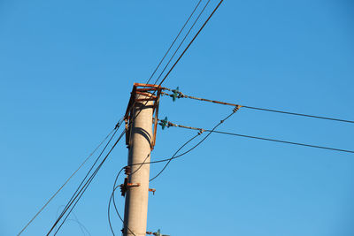 Electric pole with a linear wire against the blue sky close-up. power electric pole.
