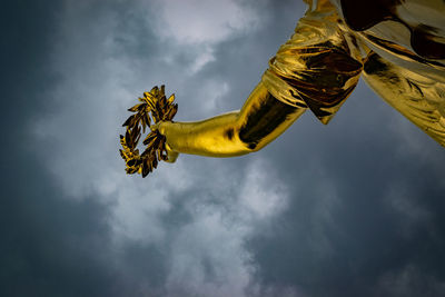 Low angle view of statue against yellow sky