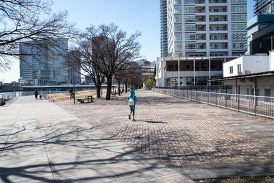 Man walking in city against clear sky