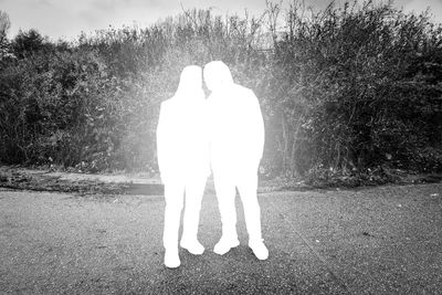 Rear view of man and woman standing on field