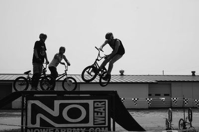 People riding bicycle against clear sky