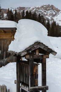 Snow covered houses against snowcapped mountains