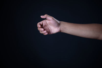 Close-up of person hand against black background