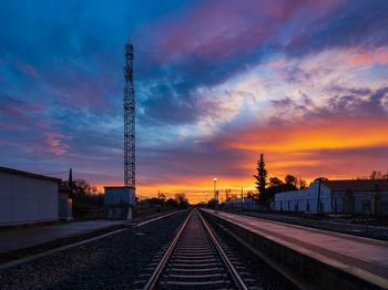 Railroad sunset with communication tower for train circulation in the front