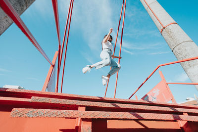 Carefree woman jumping on metal steps