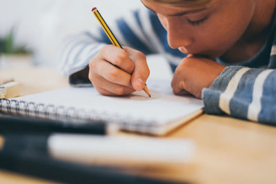 Midsection of man holding pencils on table