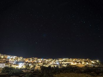 High angle view of illuminated buildings against sky at night