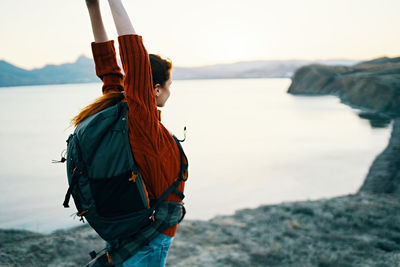 Side view of woman looking at sea against sky