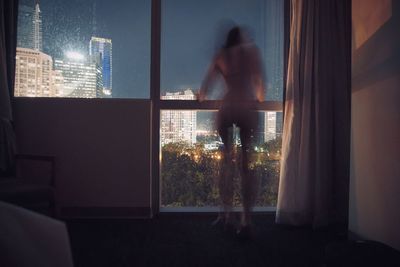 Man looking through window at home