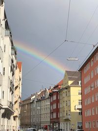 Low angle view of rainbow over buildings in city