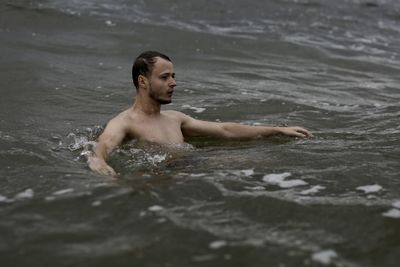 Young man swimming in sea