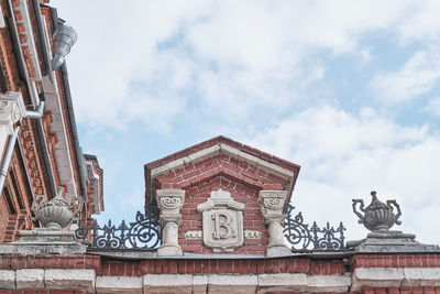 Monogram, first letter of name of russian merchant vasily gomulin, above gate of his estate of 1885