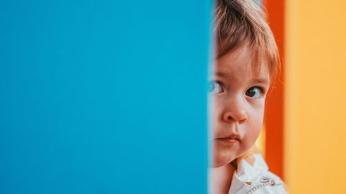 Close-up of cute girl with eyes closed against blue background