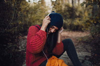 Young woman using mobile phone in forest