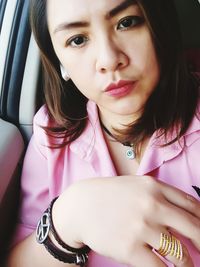 Close-up portrait of beautiful woman sitting in car