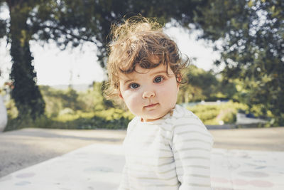 Portrait of cute boy standing against trees