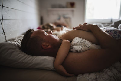 Boy sleeping on bed at home